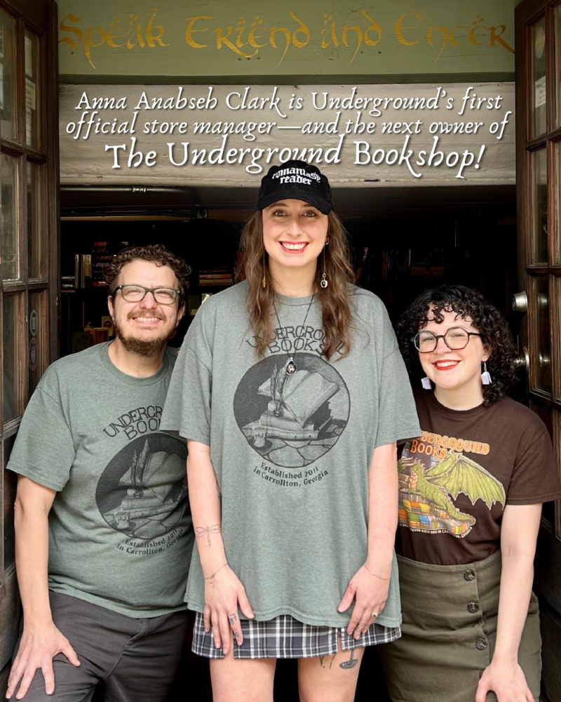 Anna standing in front of the doors of the bookstore with Josh and Megan on each side