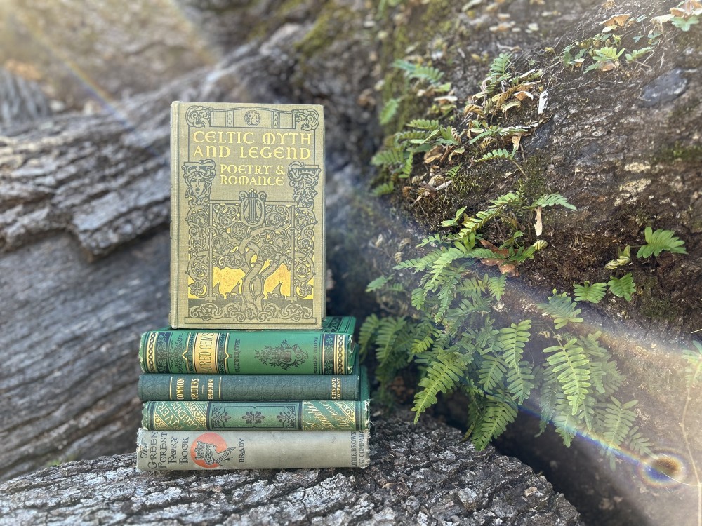 A stack of green publisher's cloth bound books on a stump
